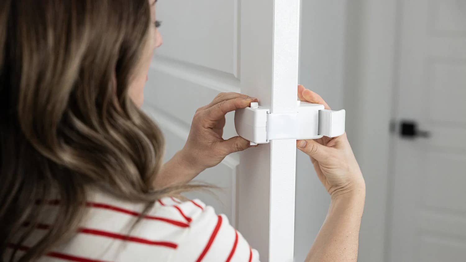 Person installing a white door lock on a door